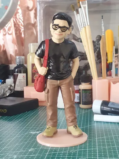Figur pria berkacamata dengan tas selempang